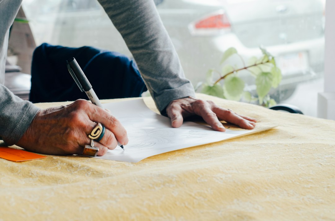 Mãos assinando um contrato de compra sobre uma mesa
